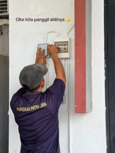 Teknisi listrik bersertifikat memasang switch di panel listrik rumah